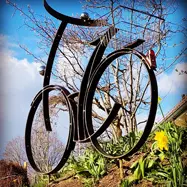 Ein Metall Fahrrad, welches in einem Garten steht